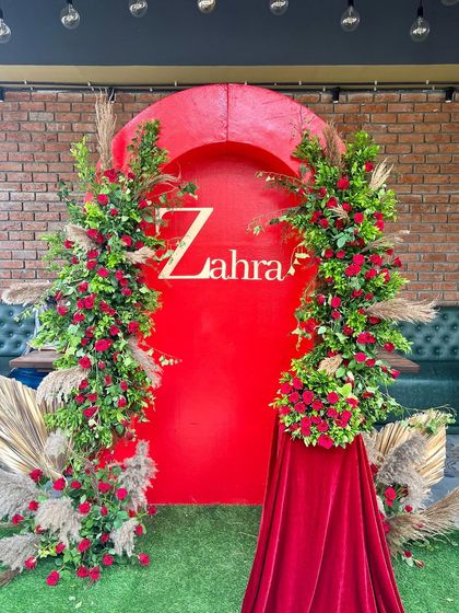 We designed this bold and beautiful bridal shower with a striking red backdrop and lush floral arches. The personalized name signage and touches of pampas grass added a modern yet glamorous feel to the event.