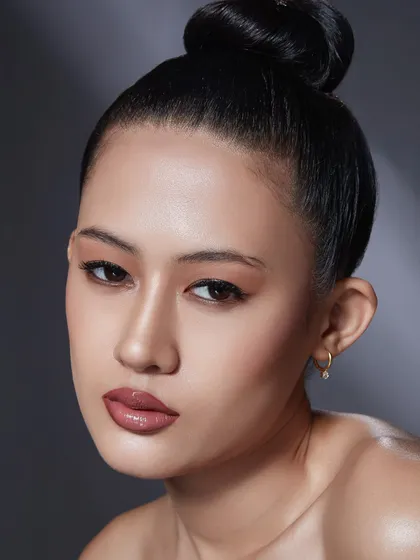 A clean, sculpted look with a high bun and a perfectly defined lip. This showcases the foundational skills of creating a polished and sophisticated beauty look.