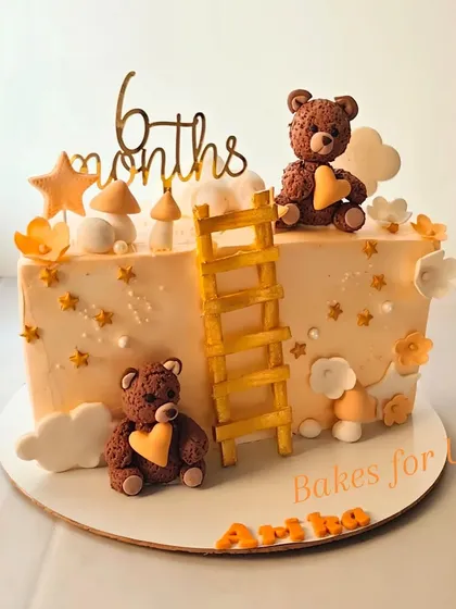 Celebrating six months with this adorable teddy bear-themed cake. It features two cute fondant bears, a ladder, and soft clouds, creating a warm and gentle design for a half-birthday.