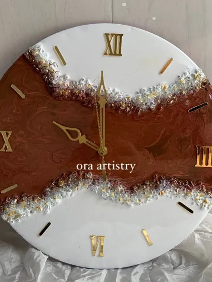 A beautiful geode-style clock with rich brown and white resin, accented with clear and gold crystals.