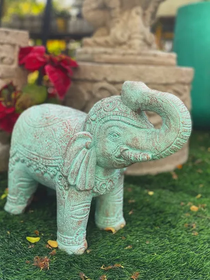Add a touch of playful elegance with our 'Savaya' elephant. This piece, finished in an antique sea green patina, features intricate detailing and an upturned trunk, a symbol of good luck.