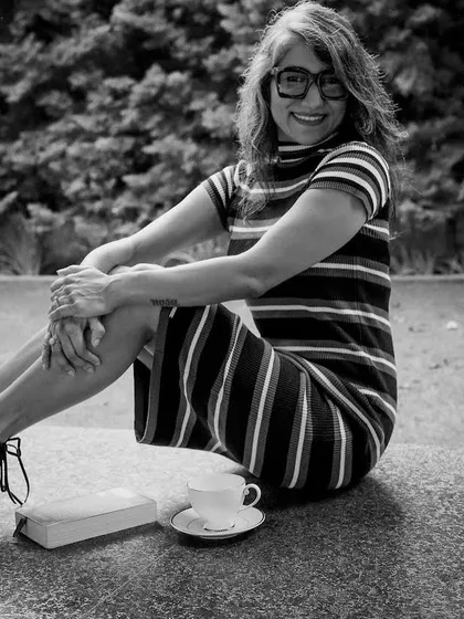 A classic black and white portrait, highlighting the timeless beauty of a simple striped dress and a happy smile.