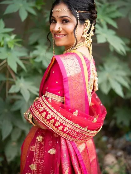 A beautiful profile shot showing the intricate details of her hair and jewellery. The makeup remains soft and elegant, allowing her traditional attire to shine.