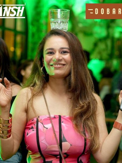 Balancing a glass and a phone, this partygoer knows how to multitask while having fun.