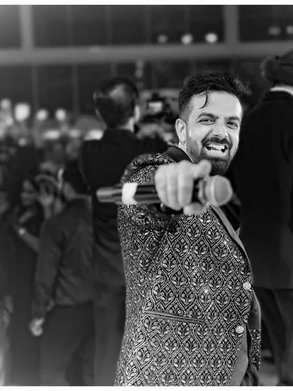A black and white shot capturing the pure joy and energy of a wedding reception party. The focus is always on the fun.