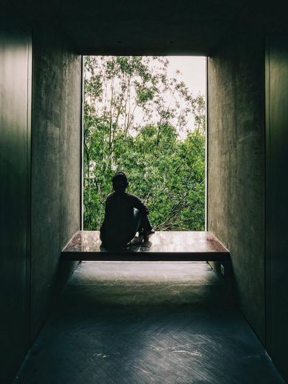 A deeply recessed window frames a view of the landscape, creating a quiet space for contemplation. The thick concrete walls provide thermal mass while the large opening offers a powerful, singular connection to the outdoors.