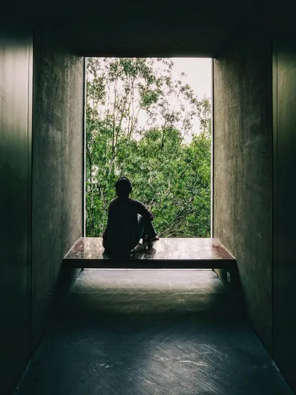 A deeply recessed window frames a view of the landscape, creating a quiet space for contemplation. The thick concrete walls provide thermal mass while the large opening offers a powerful, singular connection to the outdoors.