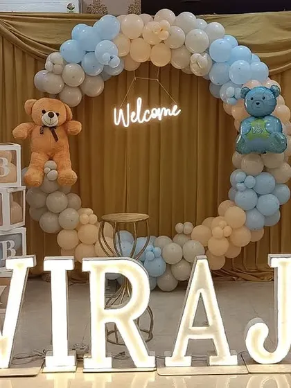 A full view of the welcome party setup for Viraj. I used a soft color palette of pastel blue, beige, and white, with multiple teddy bear cutouts and "BABY" blocks to complete the look.
