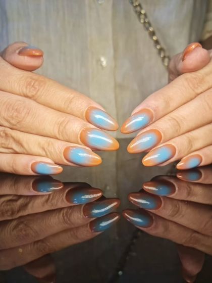 Another view of the striking blue and orange stiletto nails, showing the beautiful color combination.