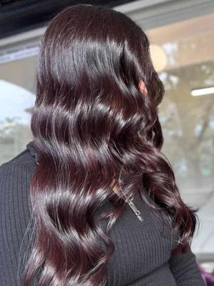A side view of the glossy, dark color, styled into soft waves.
