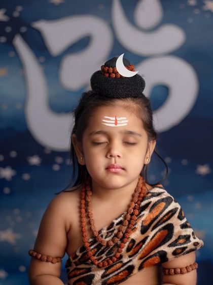 A close-up of a little girl in deep meditation as Lord Shiva, her face serene and peaceful.