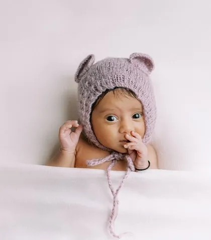 Another angle of the curious baby girl in her bear bonnet. Sometimes the most captivating shots happen when the baby is awake and engaged.