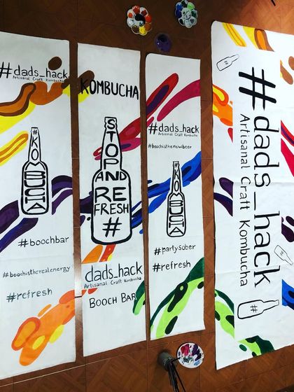 For this project, I hand-painted banners for a kombucha brand on old, discarded banner material. It's a great example of how businesses can align with sustainable practices by reusing materials creatively.