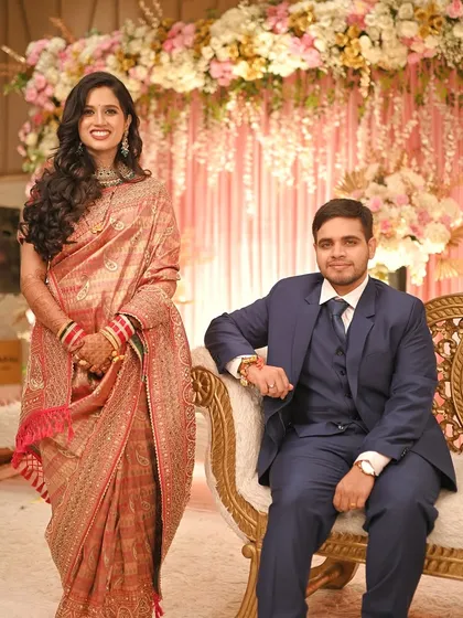 A beautiful portrait of the happy couple at their reception. The bride's elegant saree and the groom's sharp suit make for a picture-perfect pair.
