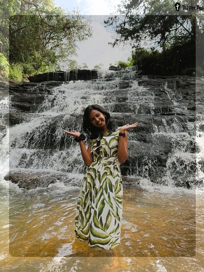 Why Kodaikanal? Because it's where calm meets chaos. A woman stands in front of a waterfall, inviting you to experience the magic of the hills, with all logistics handled by me.
