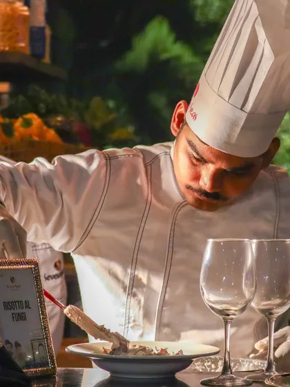 Intense focus is evident as our chef plates a Risotto al Funghi, ensuring every detail is just right.
