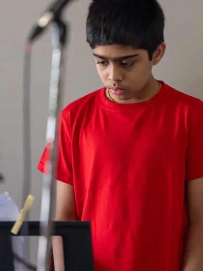 A young student, focused and determined at the keyboard. These performances are a significant part of their musical education and personal growth.