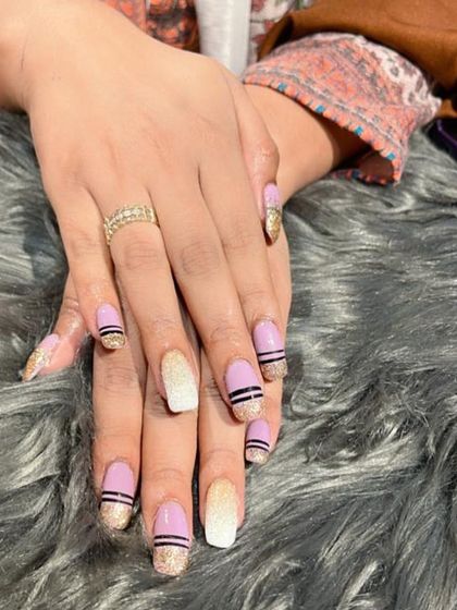 A unique mixed-finish set combining mauve polish, gold glitter, and black stripes for a creative and textured look.