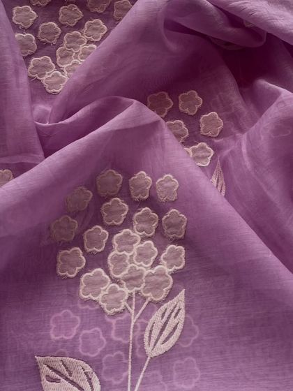 A vibrant purple Mul Chanderi with delicate white appliqué flowers. The contrast is striking, making it a wonderful choice for a statement piece.
