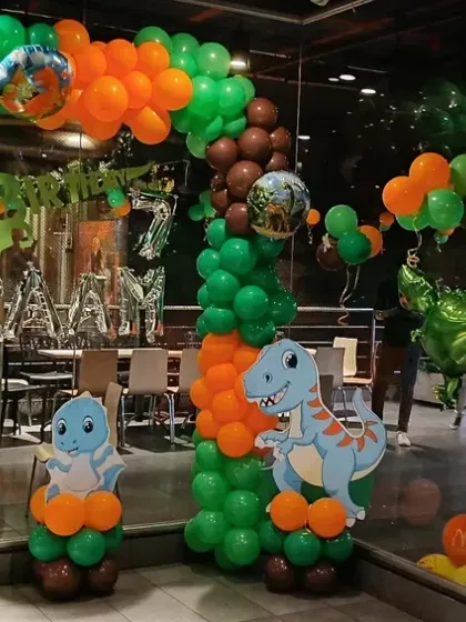 A wide shot of the elaborate dinosaur-themed balloon decoration taking over the party venue.