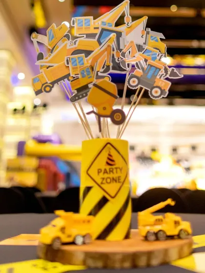 A fun and creative centerpiece for the guest tables. This "Party Zone" arrangement includes a variety of construction vehicle cutouts, making it a playful and on-theme addition to the decor.