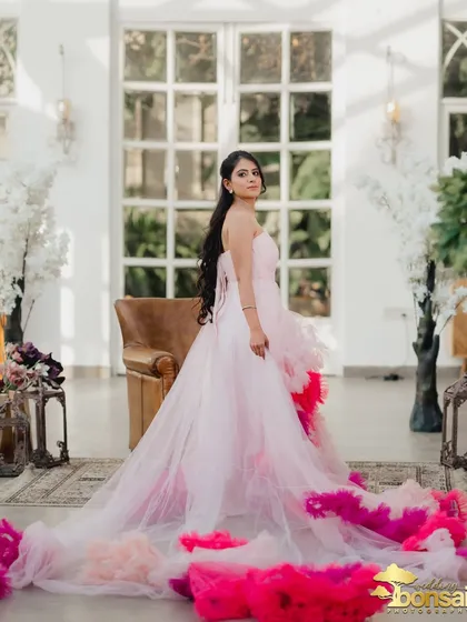 A full-length shot showcasing the incredible detail and drama of the bride's ruffled gown inside the elegant studio.