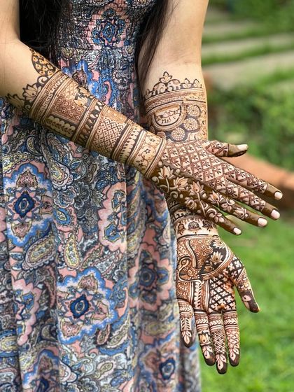 Another angle of the full-coverage bridal design, showing the back of the hands and the detailed patterns extending up the arms.
