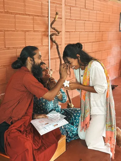 A student receives her certificate with a flower and a blessing. Graduation is a sacred and joyful ceremony, marking the beginning of her journey as a teacher.