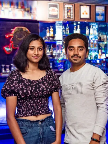 A couple posing in front of the bar.