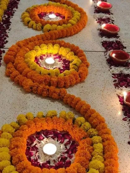 To welcome guests for a Diwali celebration, I created this spiral floor rangoli using fresh marigold strings and loose rose petals. The design is lit with traditional diyas placed in the center of each spiral.