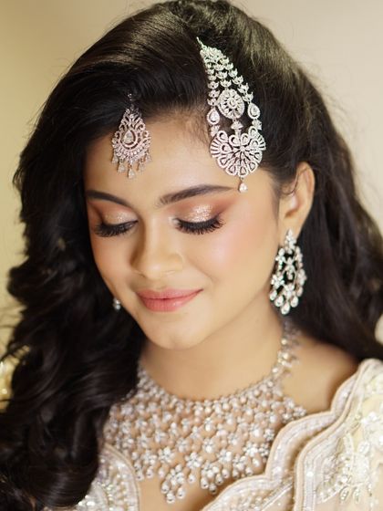 The eyes truly have it in this look. A soft wash of champagne shimmer on the lids, paired with defined lashes, creates a gaze that is both captivating and elegant.