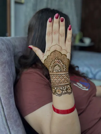A simple yet elegant design for Karwachauth, covering just the wrist and back of the hand.