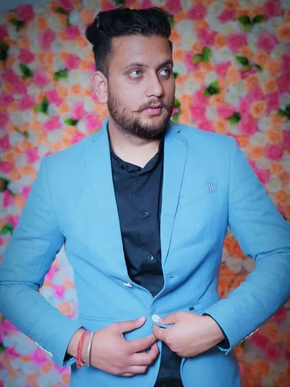 A stylish indoor portrait of a man in a blue blazer against a floral backdrop. This kind of shot is ideal for a professional headshot or a portfolio needing a smart, modern look.