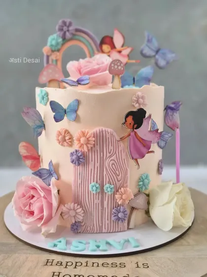An enchanting fairy garden cake with delicate butterflies, a rustic door, and beautiful flowers. The soft pastel colours make it truly magical.