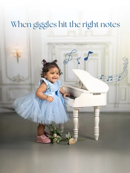 When giggles hit the right notes. This portrait captures the pure happiness of a little girl playing at her piano in a beautiful blue dress.