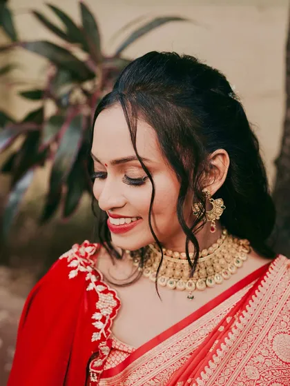 A close-up on the soft glam makeup. The subtle eye makeup and classic red lip are perfect for this bride's traditional yet modern style.