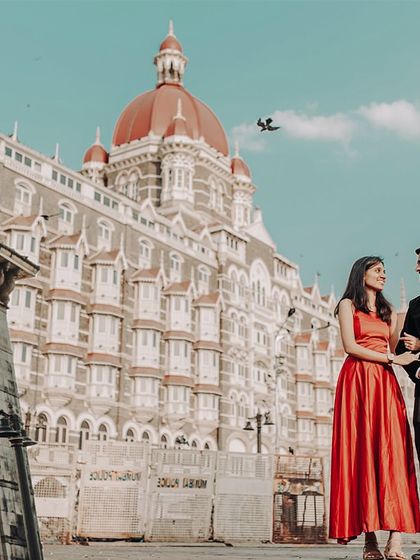 An elegant pre-wedding photo in front of the iconic Taj Mahal Palace Hotel in Mumbai, blending classic architecture with the couple's modern love story.