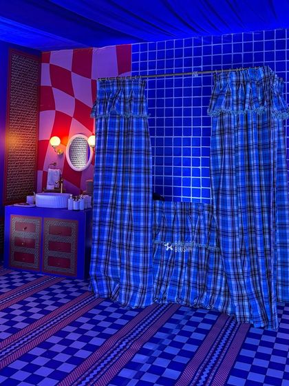The full view of the custom-designed bathroom, with plaid curtains and a blue-tiled wall.
