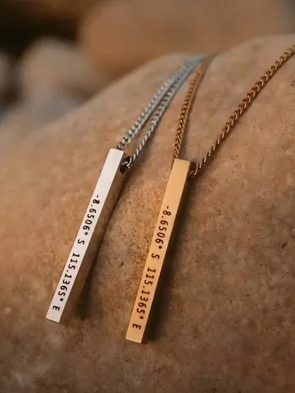 Keep a special place close to your heart with a coordinate necklace. These vertical bar pendants, shown in both silver and gold-tone stainless steel, are engraved with specific coordinates that mark a meaningful location.