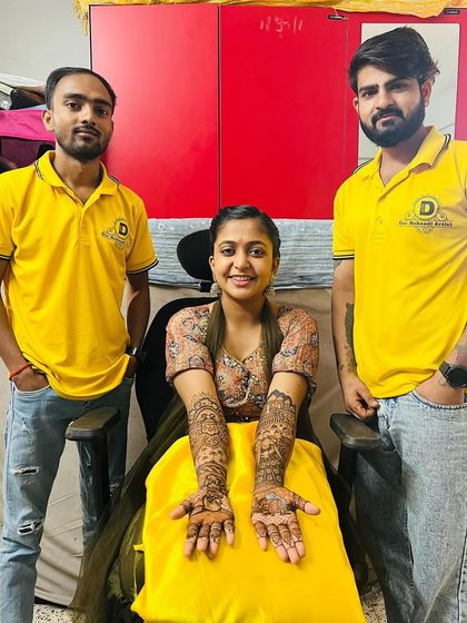 Two of my artists with a happy client, showcasing her custom portrait mehndi.