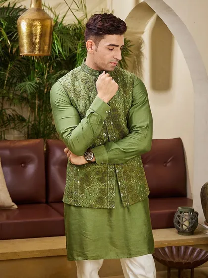 An olive green kurta paired with a meticulously embroidered matching jacket. This earthy tone is a sophisticated choice for a Mehendi ceremony or a festive gathering.