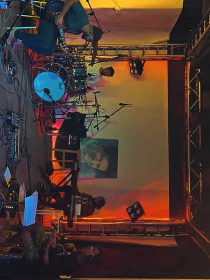 An artistic shot of the stage setup from the side, showing the drums and lighting rig before the KK tribute show.