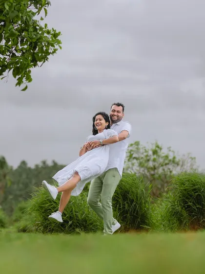 A fun and energetic lift with a backdrop of lush coastal greenery. This kind of playful interaction results in wonderfully authentic photos.