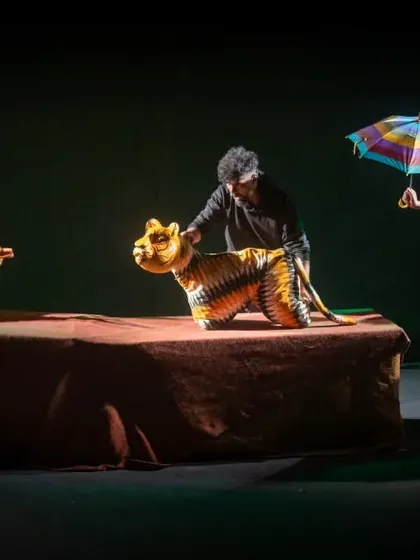 A scene from 'Be Yourself' featuring a tiger puppet made from vibrant textiles. The show is a visual celebration of Indian craftsmanship woven into a universal tale.