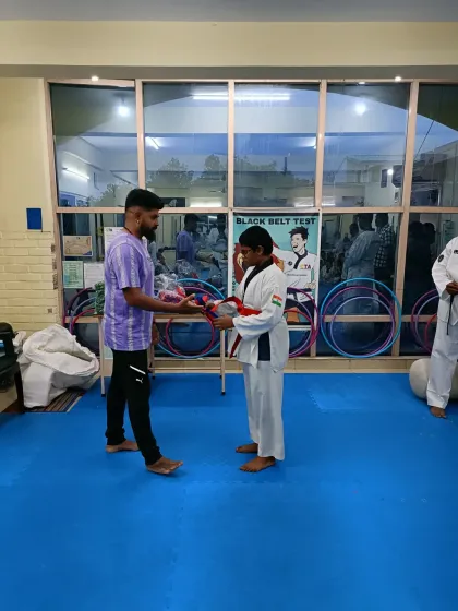A student receives his red belt.