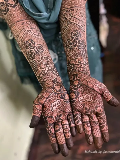 A close-up of the palm work on Rushda's bridal henna, featuring personalized name details hidden within the design.