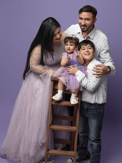 A picture-perfect family of four. Posing on and around a small ladder adds a dynamic and interesting composition to this happy family portrait.