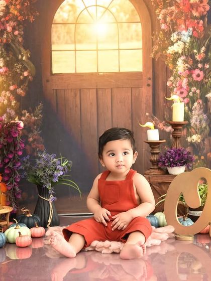 A rustic, warm-toned setup for a little boy's first birthday. The "One" sign and cozy details create a charming and timeless portrait.