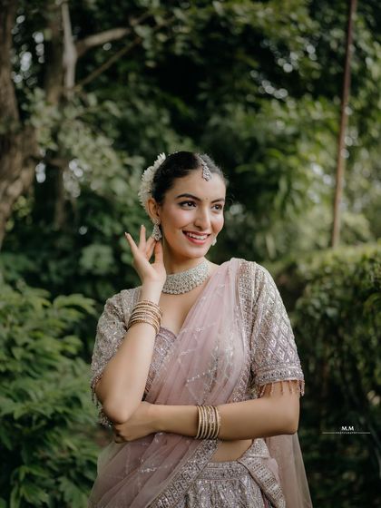 A radiant smile and a graceful pose. This portrait highlights the bride's happiness and the delicate beauty of her pastel lehenga and jewelry.
