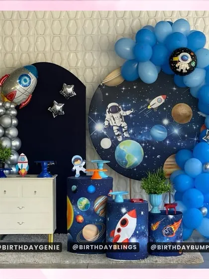 This space theme features a circular galaxy backdrop and a separate panel with a silver rocket. The themed plinths are designed to look like planets.